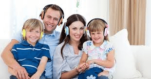 Mother and son share headphones, smiling as they listen to a dedicated song for the son.